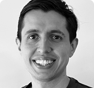 A black and white photo of a man smiling.